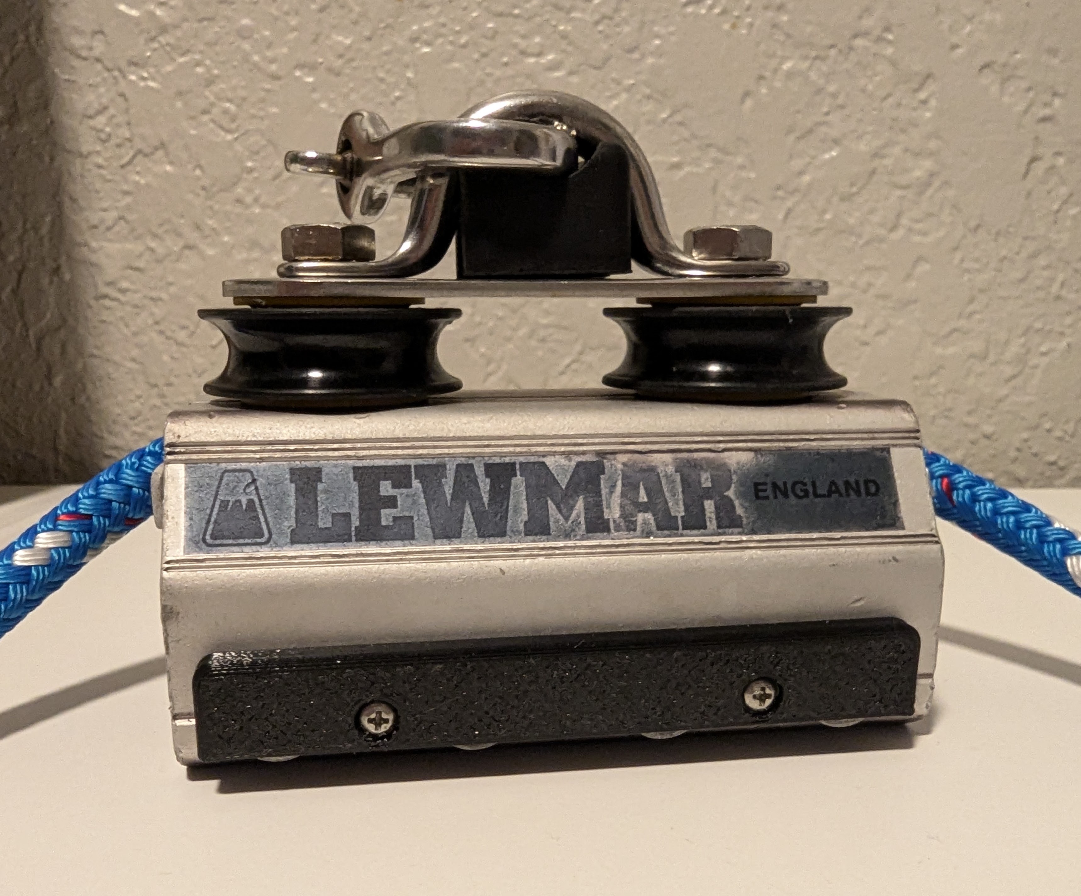 Exterior side view of reassembled car with new ball bearing sheaves, new blue control line, and black plastic pin retainer visible.